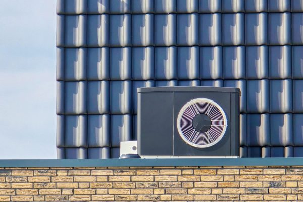 air source heat pump unit installed outdoors at a modern home with bricks in the Netherlands in spring, warmte pomp translation air source heat pump, carbon neutral zero emissions
